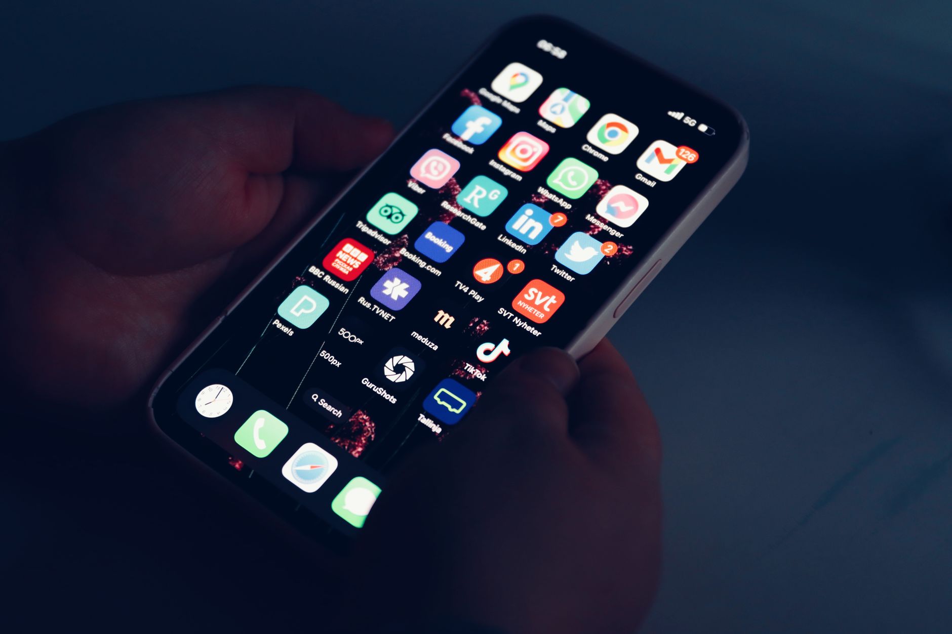 Hand holding a smartphone in a dark room at night