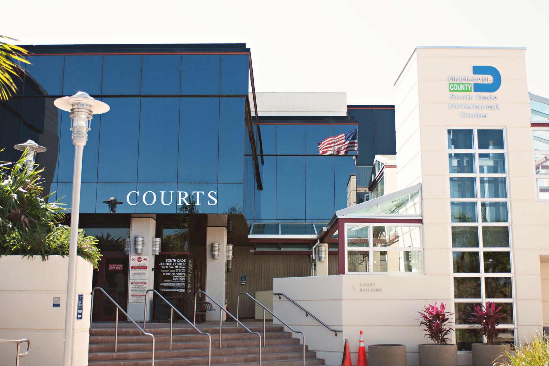 Courthouse entrance with a Courts sign and palm trees